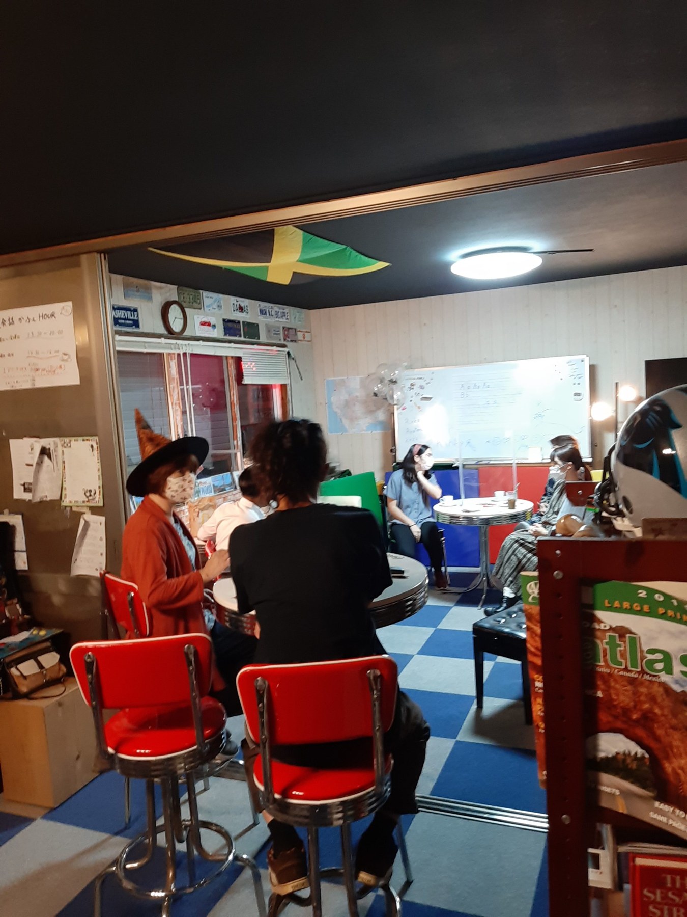テーブルを囲んで英会話カフェに参加する人たち。2021年の店内の様子